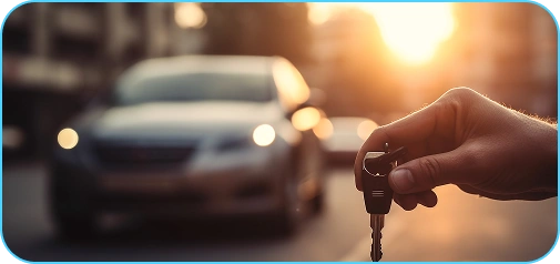 Warme cinematische afbeelding van een persoon die autosleutels vasthoudt met een vervaagd voertuig op de achtergrond tijdens het gouden uur